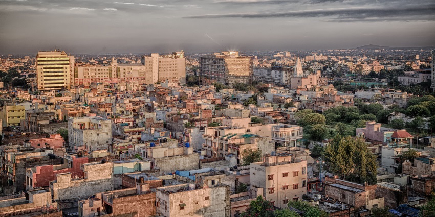 A panoramic view of the Indore skyline, showcasing a mix of modern and traditional buildings against a clear sky.