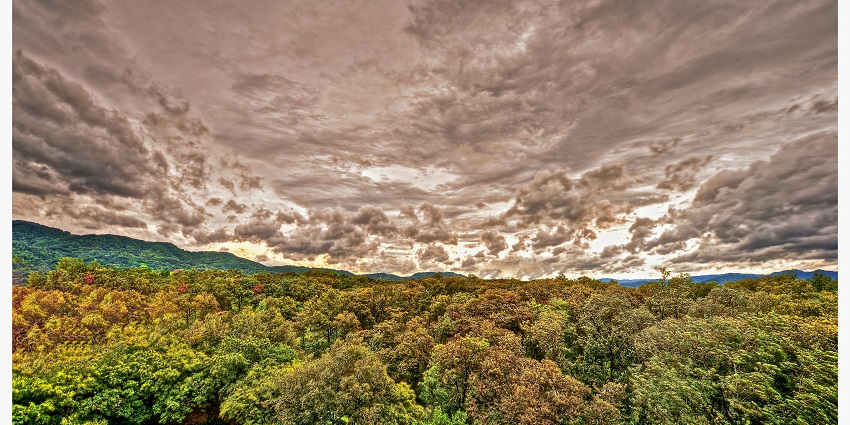 A monochrome photo of a mountain range during the monsoon with clouds dominating the sky.
