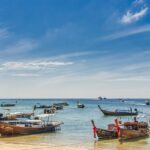 An image of several boats in the waters of Krabi which is a tropical paradise in Thailand.