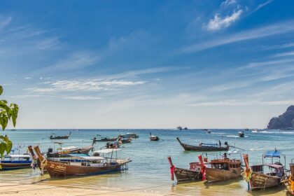 An image of several boats in the waters of Krabi which is a tropical paradise in Thailand.