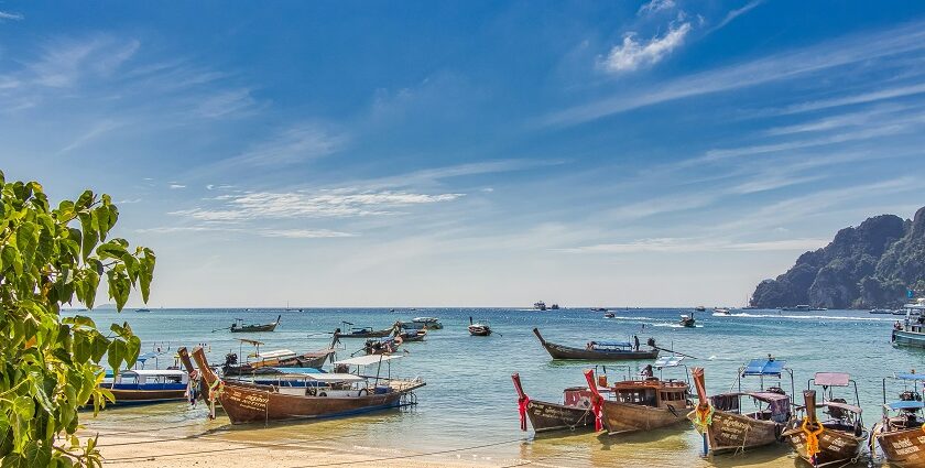 An image of several boats in the waters of Krabi which is a tropical paradise in Thailand.