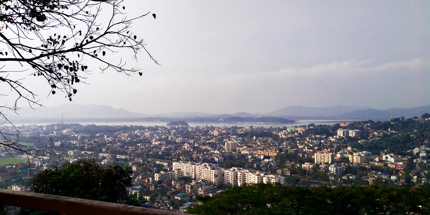 A breathtaking aerial view of a city in Assam with a lot of houses during the daytime.