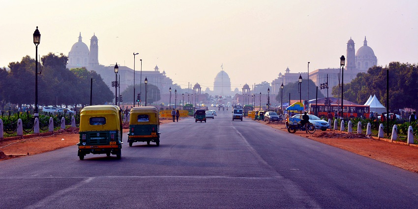 A breathtaking view of Delhi with autos and cars on the road during the daytime.