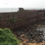 Panoramic view of the walls of Betul fort lining the serene waters at its border