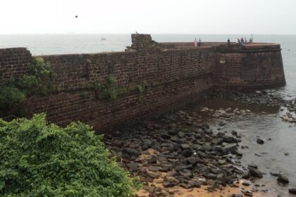 Panoramic view of the walls of Betul fort lining the serene waters at its border