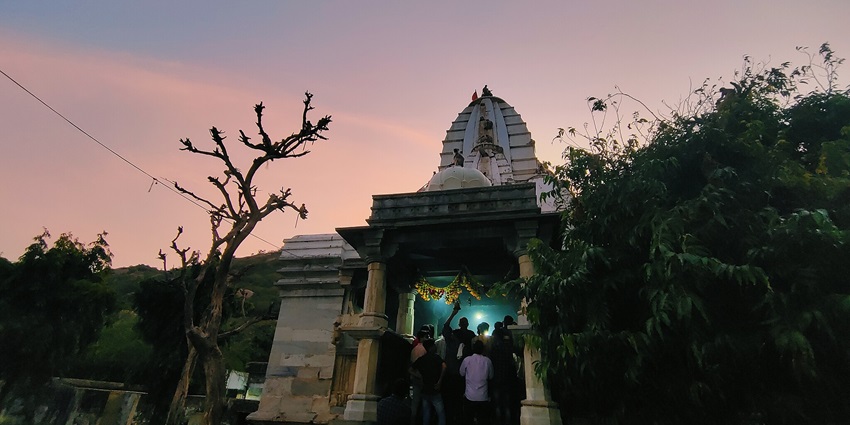 A group of believers worshiping at the temple during a picturesque evening.