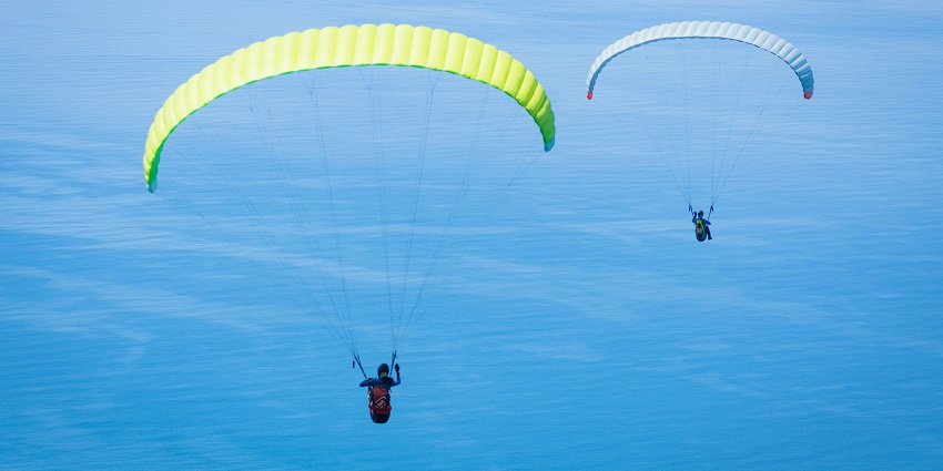 Group of people skydiving through the sky, experiencing an adventure with expansive views.