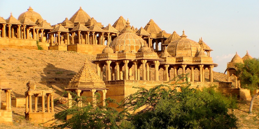 An ancient stepwell with detailed carvings, surrounded by historical structures.