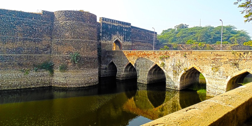 A picture of the historical Bharatpur Fort with a canal flowing in front of it