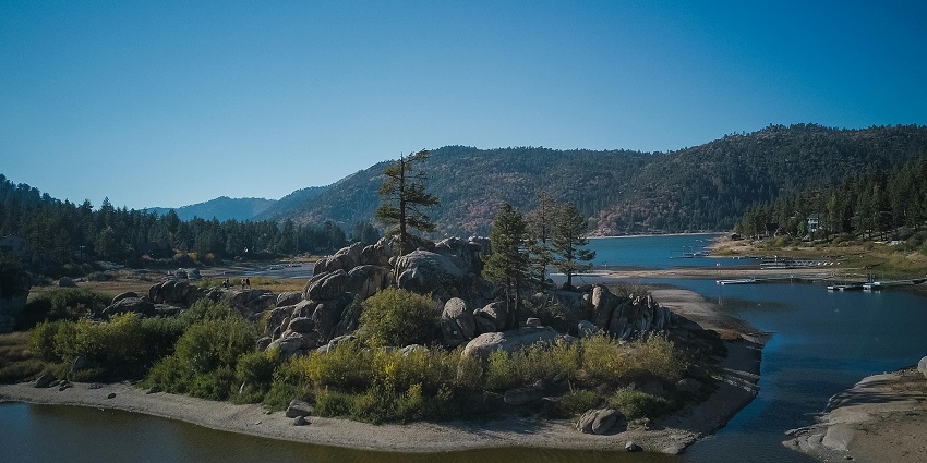 A view of Bheemkund, a natural water reservoir surrounded by lush greenery and rocky terrain.