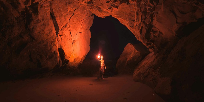 An image of the Bhimbetka Caves with prehistoric paintings visible on the walls.