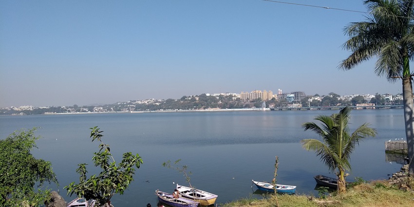 Serene view of Bhopal Lake, the famous place near Salkanpur Temple, with calm waters reflecting the surrounding green hills.