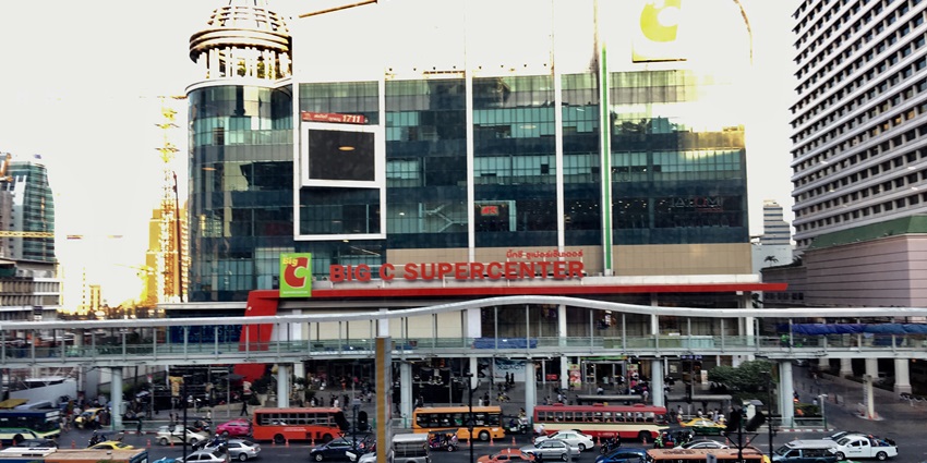 A picture of a massive supermarket taken from outside with cars parked in front of it