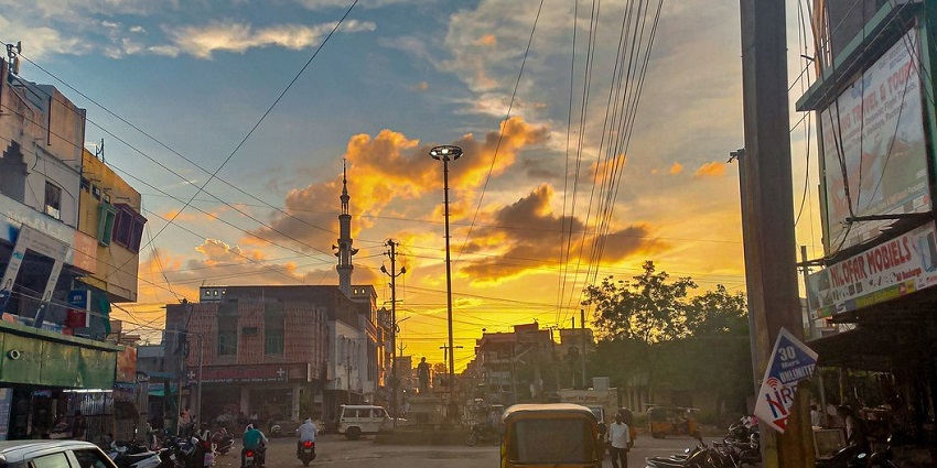 Birbal Chowk in Sri Ganganagar during sunset, with vehicles and people going about their daily lives.