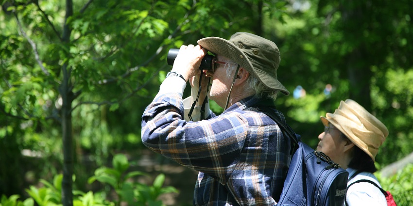 Birdwatcher observing birds through binoculars near the Balimela Reservoir