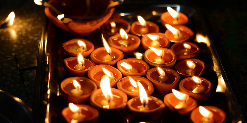 A simple close-up of the diyas lit up in a sacred site similar to Birla Mandir, one of the Jaipur temples.