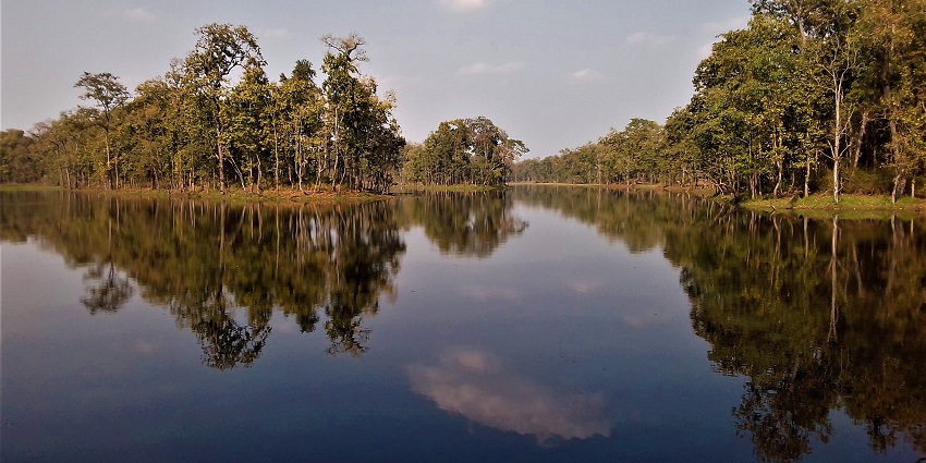 Wide-angle shot of Bishazari Tal, capturing its freshwater lake and surrounding greenery.