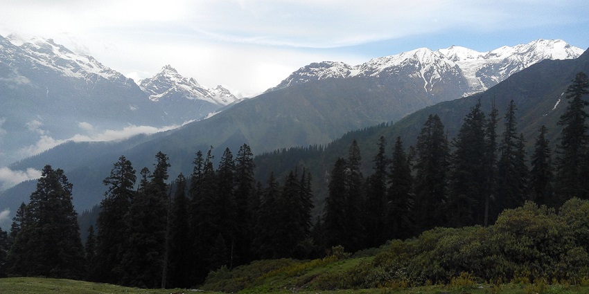 A panoramic view of Biskeri Thach, showing a vast meadow and trekking trails around Sar Pass