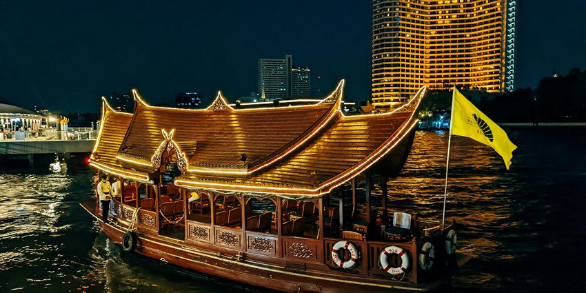 Beautiful view of the illuminated Chao Phraya river night cruise under the night sky.