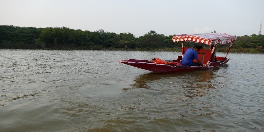 Visitors enjoying a boat ride on Kanjia Lake, surrounded by lush vegetation.