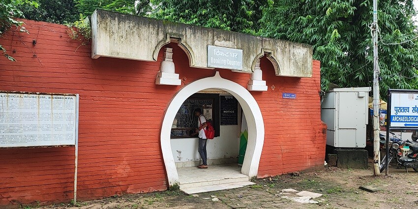 Ticket counter at Bodh Gaya Museum with a simple brick structure and glass windows.