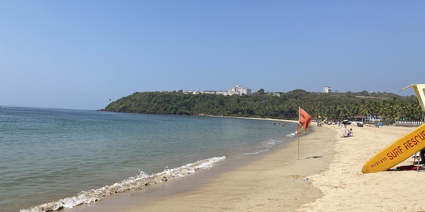 A picture of a beach near Arambol with a surf board laying around the shore