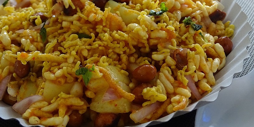 Image of a plate of chatpati bhel puri topped with sev, onions, and fresh coriander leaves