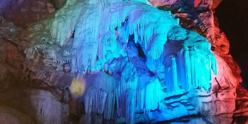 A picture of a cave system in Araku with multi colour lightings flashed on the cave rocks