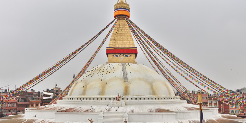 The Boudha Stupa in Kathmandu, Nepal, featuring its iconic dome and colorful prayer flags.