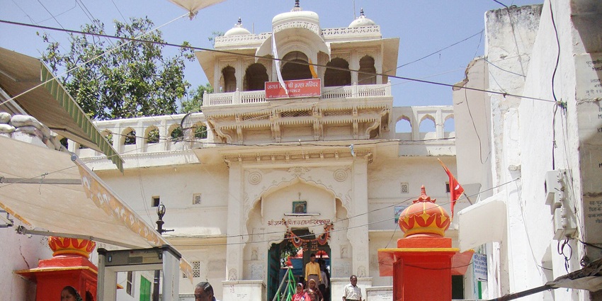 Brahma Temple in Pushkar showcases red spire, marble statue, pilgrimage site.