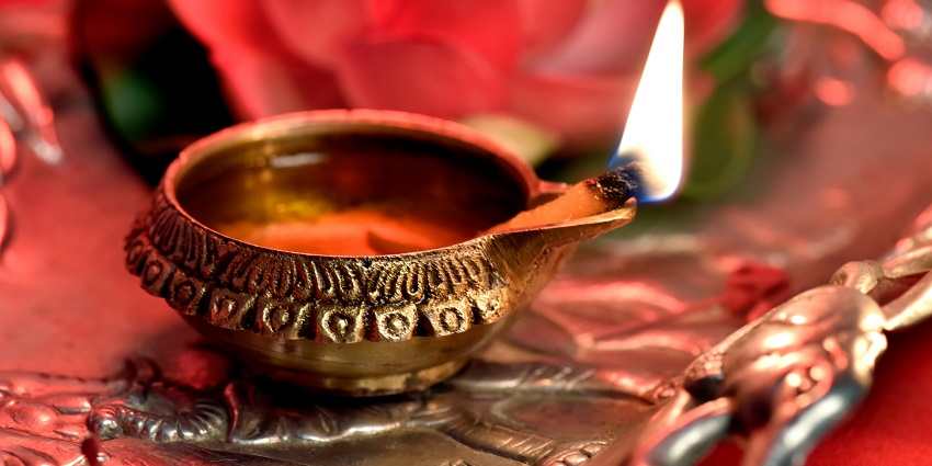 An image of a diya lit up in a colourful site like Brahma Temple which is a unique temple.