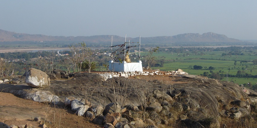 A scenic view of Brahmayoni Hills surrounded by lush green trees where Lord Buddha preached Fire Sutta.