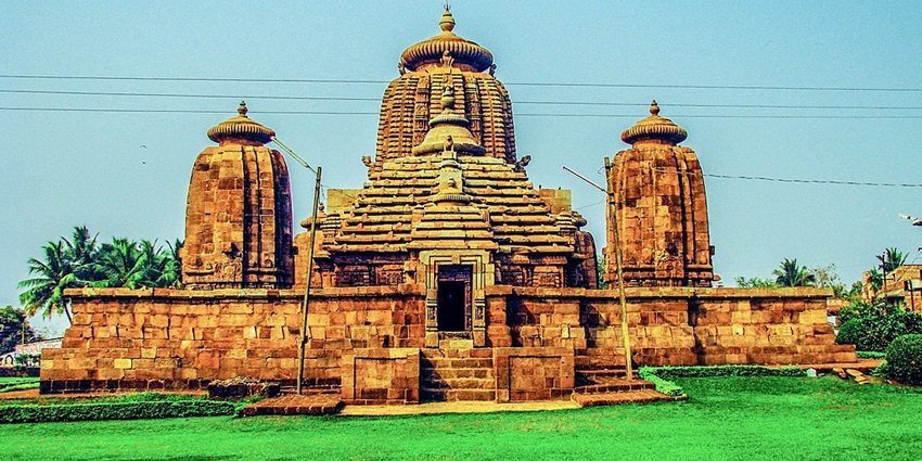 A grand view of Brahmeshwar Temple, showcasing its numerous towers and a white flag.