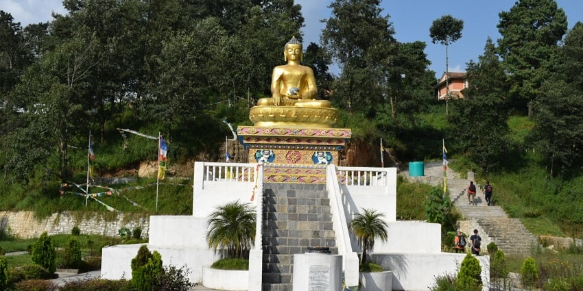 Scenic view of Nagarkot Stupa surrounded by lush greenery and distant mountains.