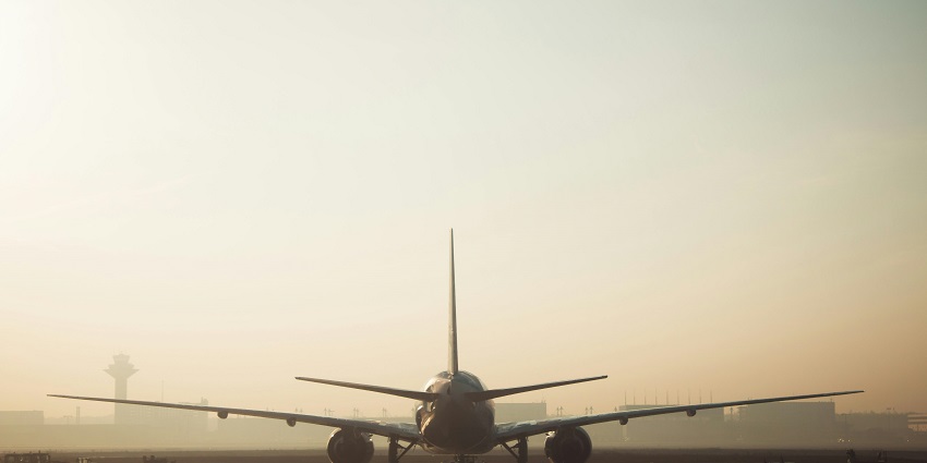 White and grey skies in the backdrop of the aeroplane, showcasing the landing of a plane.