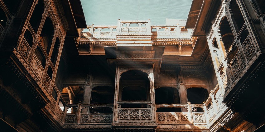 The towering brown concrete building of the Bundi Museum with symmetrical windows under a clear sky.