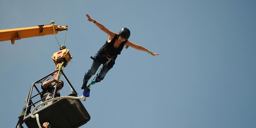 Adventurer free-falling from the Bhote Koshi Bridge during a bungee jump during the day.