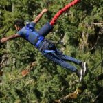 A breathtaking view of a person enjoying an adventurous activity surrounded by greenery.