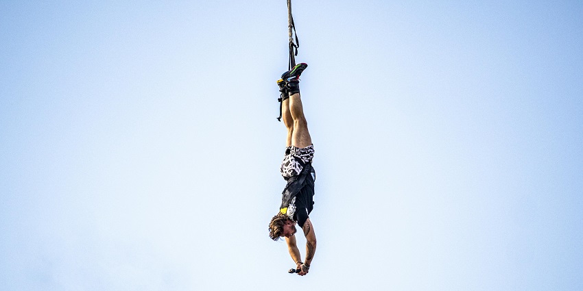 A man hanging upside down on a rope while bungee jumping