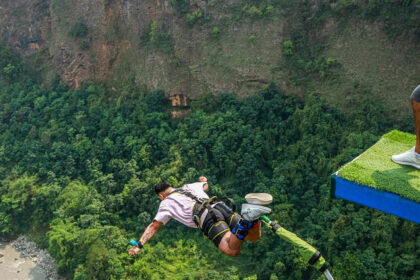 Image of a man bungee jumping in Manali with lush landscapes down the cliff