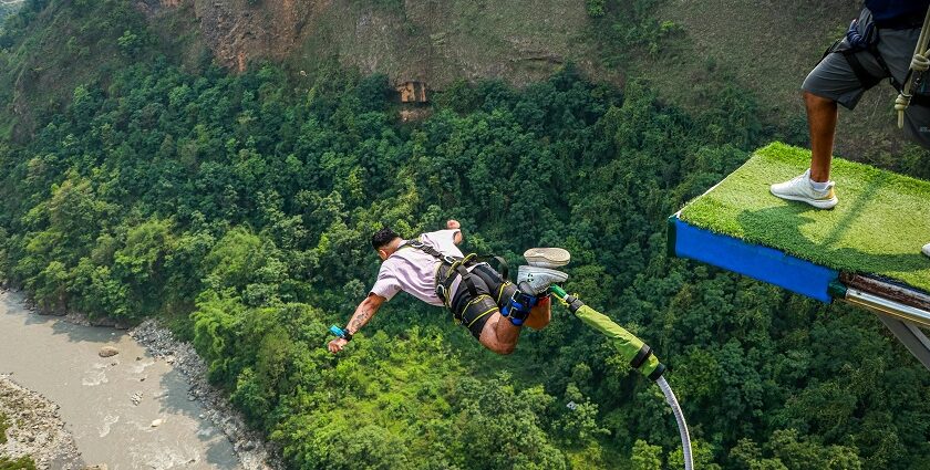 View of an Adventurer bungee jumping in Nepal, falling from the top with a hanging rope.