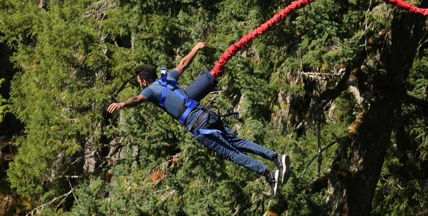 A breathtaking view of a man enjoying an adventure activity around lush greenery.