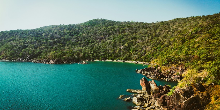 An aerial view of the Butterfly Beach featuring azure waters and lush green vegetation.
