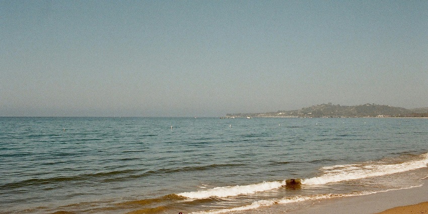 A scenic view of sprawling cobalt-blue waters and golden shores of the Butterfly Beach.