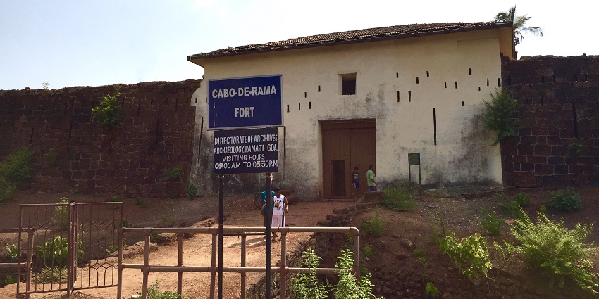 A picture of a fort's entrance in Goa with the fort walls spreading wide
