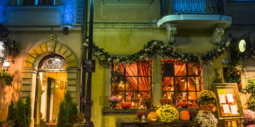 A front view of the Cafe Alchemia assorted with colourful flowers and beautiful lights.