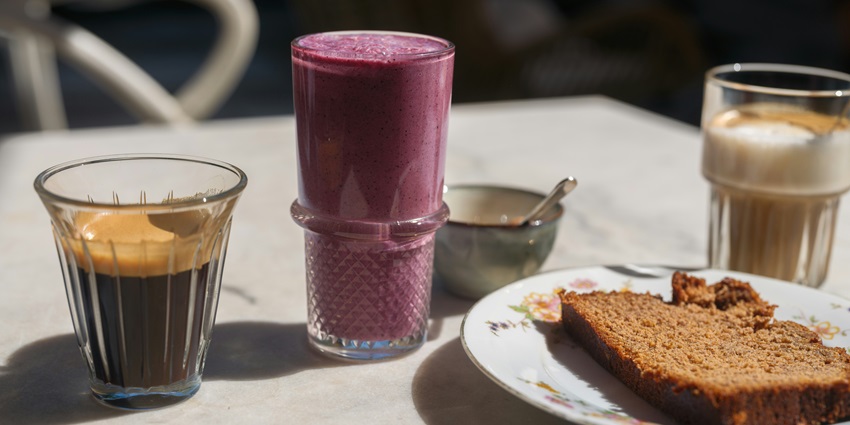Image of coffe, blueberry smoothie and a chocolate brownie served on a table - explore the cafe choco craze