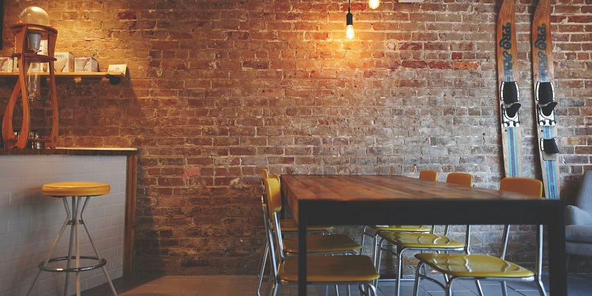 A cosy dining area featuring a brown wooden table and a stylish mini bar in warm tones