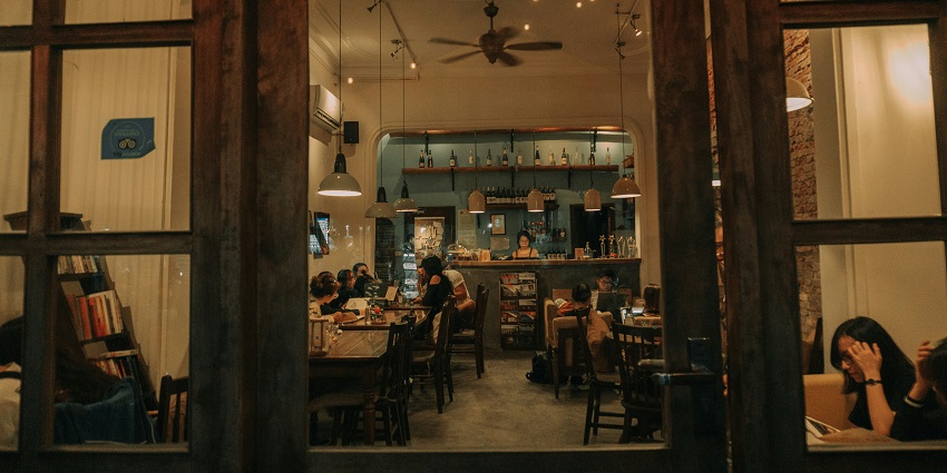 A group of friends enjoying a meal together at a cosy restaurant table, sharing laughter