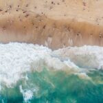 A bird’s eye view of the turquoise blue waters meeting the golden pristine sands.